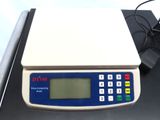 the electronic scale is sitting on the table next to a laptop