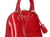a red handbag with gold hardware on the handle