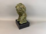 a close up of a bronze statue of a man ' s head on a black base