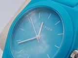the watch is blue and has a white face and hands