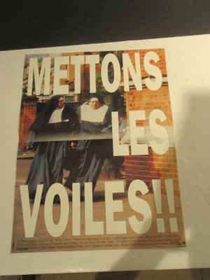 une affiche accrochée au mur d'un immeuble sur laquelle on peut lire « Meltons Les Volles »