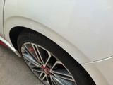 a close up of a white car parked on the side of the road