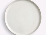 a white plate on a table with a spoon and fork
