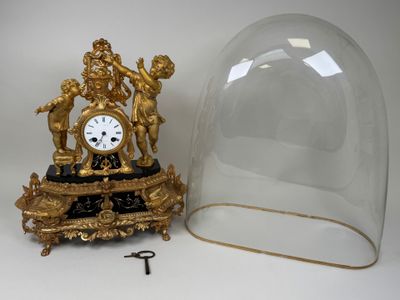 une horloge en or sous un dôme de verre sur une table