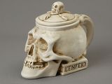une tasse blanche en forme de crâne, munie d'un couvercle et ornée d'un crâne