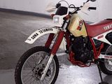 a red and white dirt bike parked in a garage