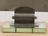 a metal object on a glass plate on a wooden table