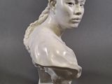 a white marble bust of a woman with braids on her hair