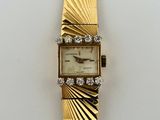 an image of a gold watch with diamonds on a white surface