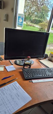un bureau sur lequel se trouvent un ordinateur, un clavier, une souris et des papiers