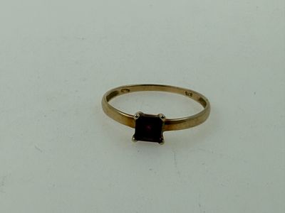 an image of a gold ring with a garnetite stone