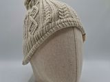 knitted hat with pom pom on top of a mannequin head