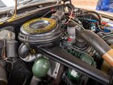 a close up of a car ' s engine with a baseball bat sticking out of it ' s hood