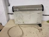 a white heater sitting on top of a table next to a wall