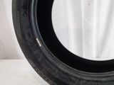 a close up of a tire on a white surface with a curtain in the background
