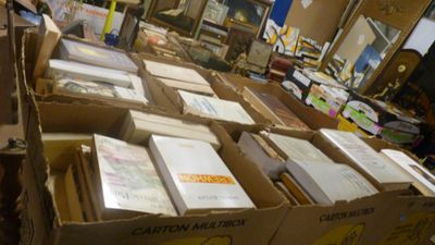 de nombreuses caisses de livres posées sur une table dans une pièce