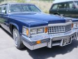 une voiture bleue garée dans un parking à côté d'autres voitures