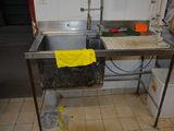 un évier sur lequel est posée une serviette jaune, dans une cuisine
