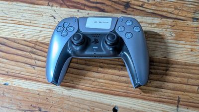 un gros plan d'une manette de jeu posée sur une table en bois