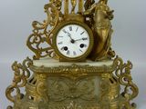 a gold clock sitting on top of a white table