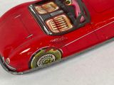 a red toy car that is sitting on a white surface
