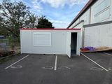 an empty parking lot in front of a building with a red roof