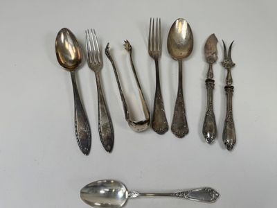 a lot of silver spoons and forks on the table
