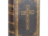 un vieux livre sur lequel est posée une croix