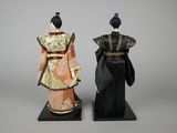 pair of asian dolls of women dressed in traditional clothing on stands