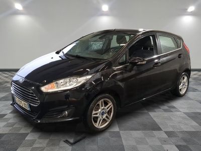 une voiture noire est garée sur le sol en damier d'un garage