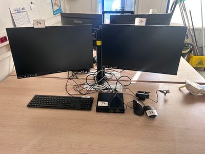 two computer monitors sitting on a desk with a keyboard and mouse