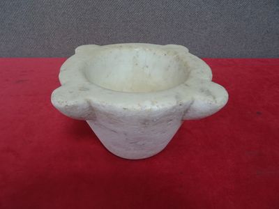 un petit vase blanc posé sur une nappe rouge