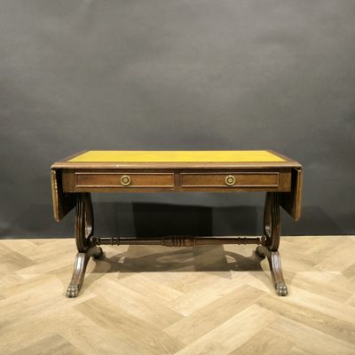 an antique writing table with two drawers and a yellow top