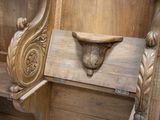 a wooden bench that has a carved head on it