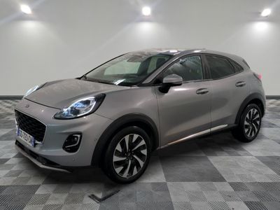 Une voiture argentée est garée dans une pièce au sol en damier.