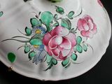 a white bowl with flowers painted on it on a table