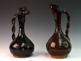 two brown vases sitting side by side on a white surface