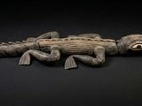 une image représentant un alligator en peluche posé sur une surface noire