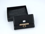 black leather wallet with a gold buckle in a black box