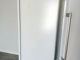 a white refrigerator and a white refrigerator freezer in a room