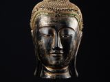 une tête de Bouddha en bronze sur fond noir