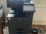 a printer that is sitting on the floor in front of a window