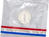 the coin is in a plastic bag with a red, white, and blue stripe