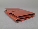 a brown wallet sitting on top of a gray table