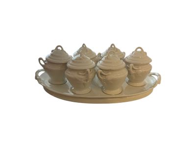 a tray that has a tray with four different teapots on it