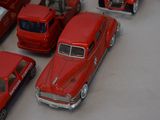 a lot of red toy cars that are on a table
