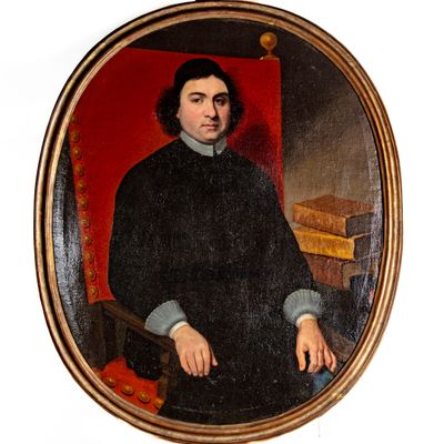 portrait d'un homme vêtu d'un manteau noir, assis dans un fauteuil rouge