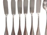 a lot of spoons and knives that are on the table