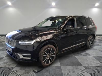 un SUV Volvo noir garé sur un sol à damier dans un showroom