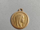a close up of a gold medal with a woman ' s face on it